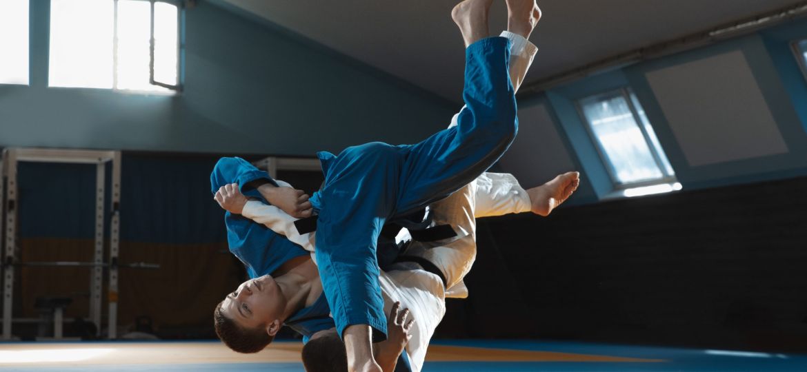 Two young fighters in kimono training martial arts in the gym