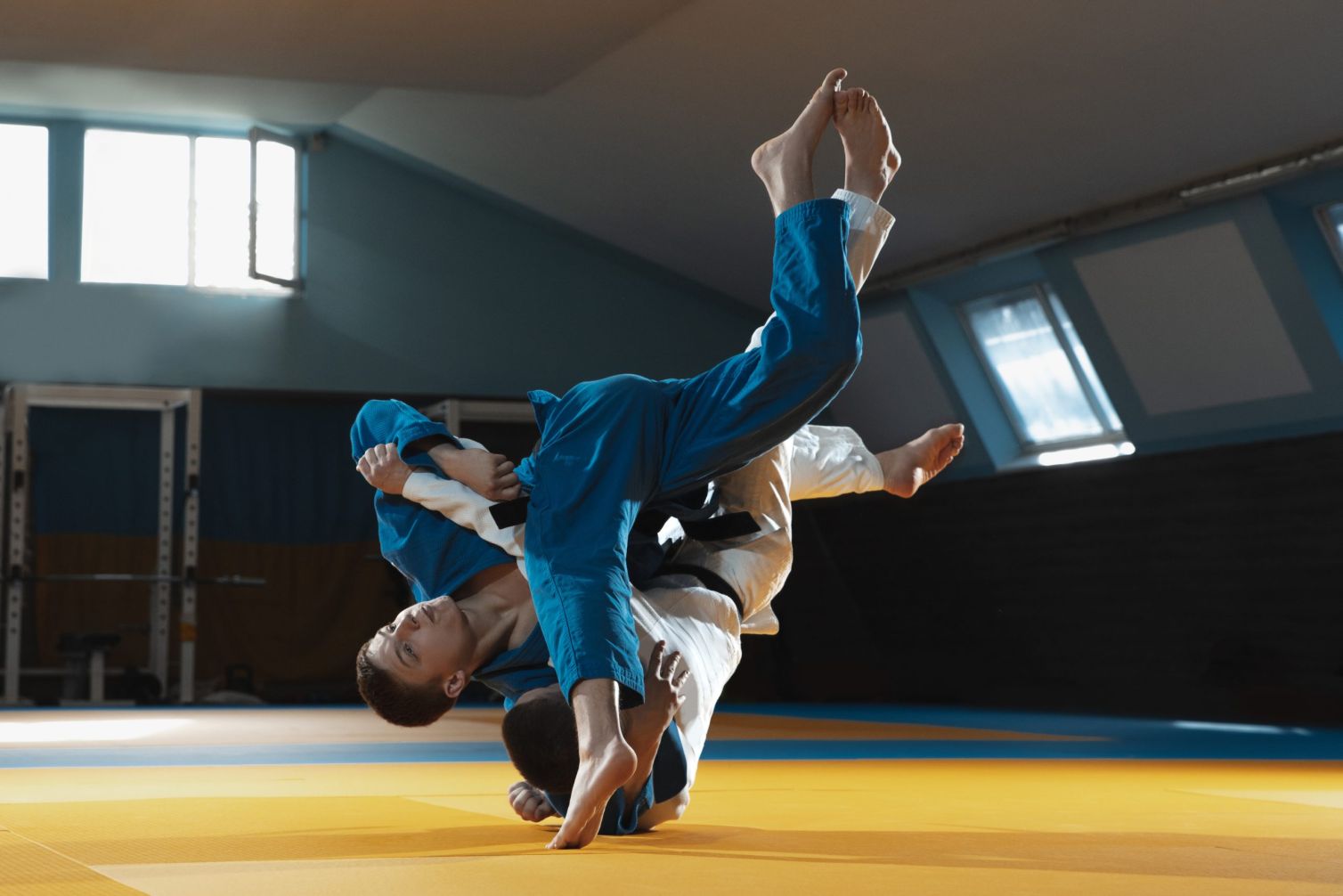 Two young fighters in kimono training martial arts in the gym